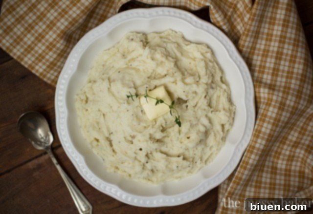 An OXO Good Grips Food Mill being used to process cooked potatoes into a smooth puree.