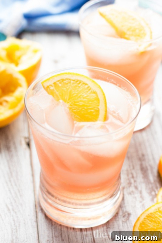 Ingredients for Cranberry Orange Crush laid out on a table, including fresh oranges and cranberries.