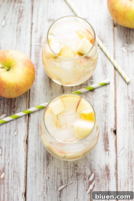 Fizzy Caramel Apple Sangria 7 Caramel Apple Sangria being poured into a glass, showcasing its vibrant color and fizz