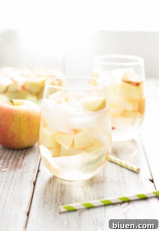 Fizzy Caramel Apple Sangria 9 A large pitcher of Caramel Apple Sangria with fresh apples and ice, ready for serving
