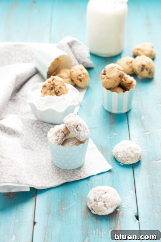 Grandmom's Pecan Sandies | A stack of Pecan Sandies heavily dusted with powdered sugar, ready for serving.