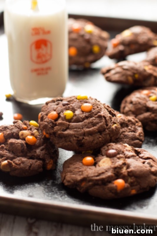 Stack of freshly baked Chocolate Reese's Pieces Pudding Cookies, showing their thick, soft texture