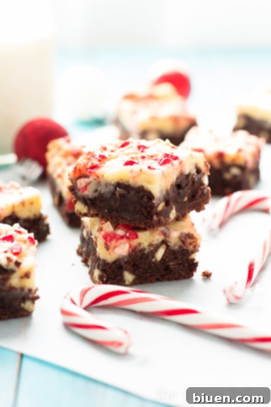 A close-up of a single square of Peppermint Cheesecake Swirl Brownie, showcasing the peppermint chip topping