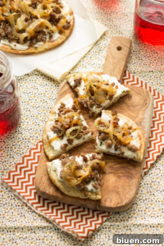 Sausage & Caramelized Onion Pita Pizza - A delicious game day appetizer with savory sausage, sweet caramelized onions, and creamy ricotta on grilled pita bread.