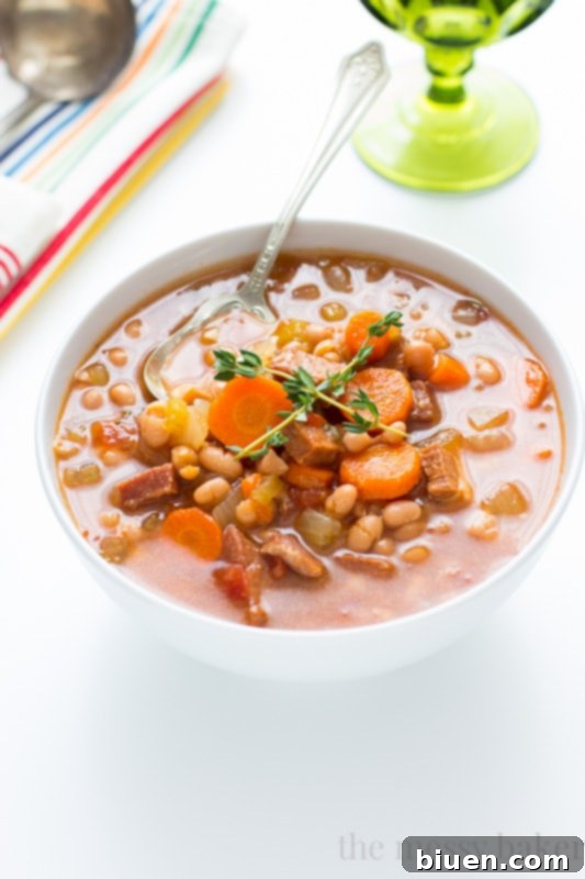 Close up of a bowl of Slow Cooker Navy Bean Soup with Ham and crusty bread