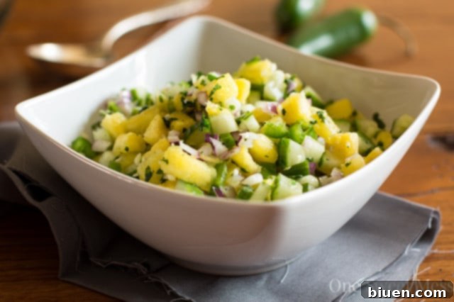 Pineapple Cucumber Salsa in a serving bowl on a rustic surface