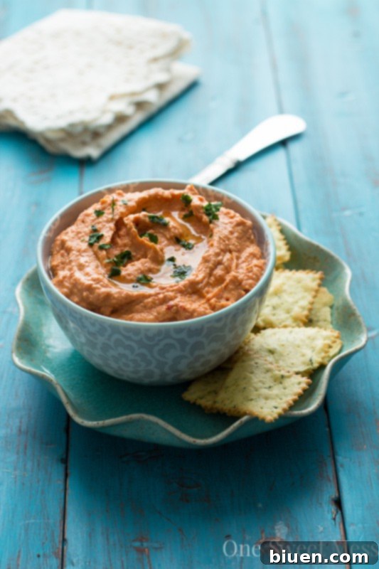 A bowl of freshly made Sun-Dried Tomato & Roasted Red Pepper Hummus, ready to be served.