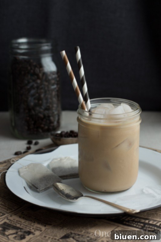 Making a homemade Dirty Chai Tea Latte, pouring milk into chai and espresso