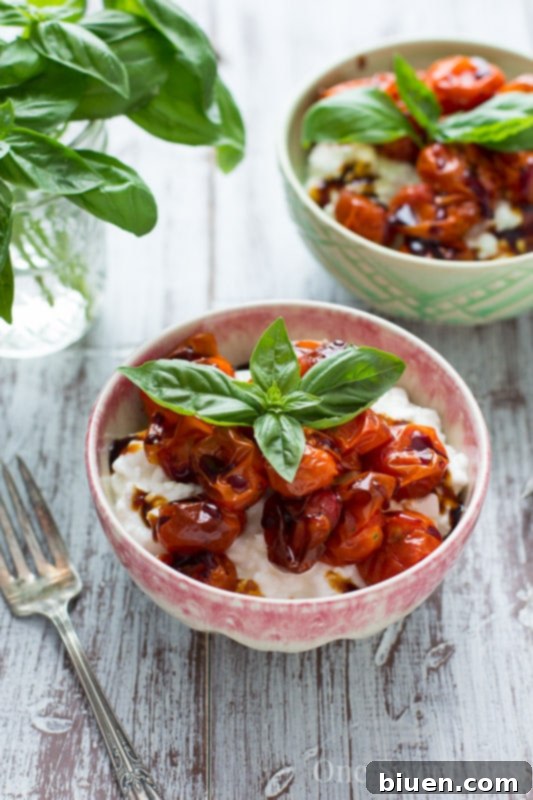 Close-up of a vibrant Roasted Tomato Basil Cottage Cheese Bowl with a spoon, highlighting the texture of cottage cheese, roasted tomatoes, and fresh basil.