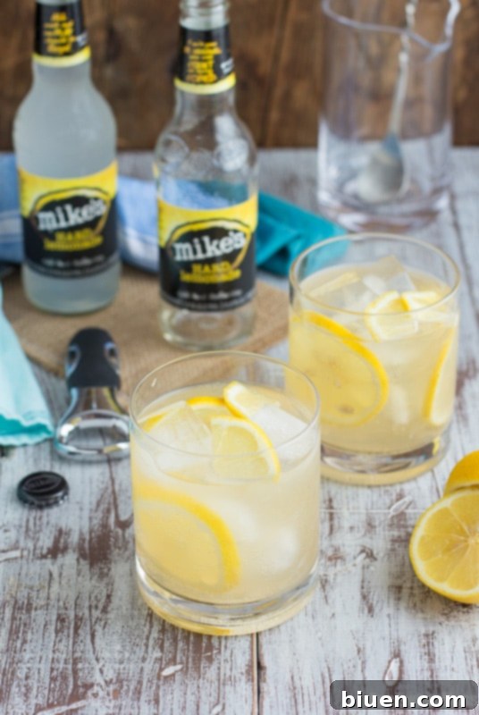Thirsty Thursday Vanilla Bourbon Quencher 7 An assortment of Mike's Hard Lemonade 'Flavors of America' variety pack bottles displayed alongside a glass of Vanilla Bourbon Lemonade.