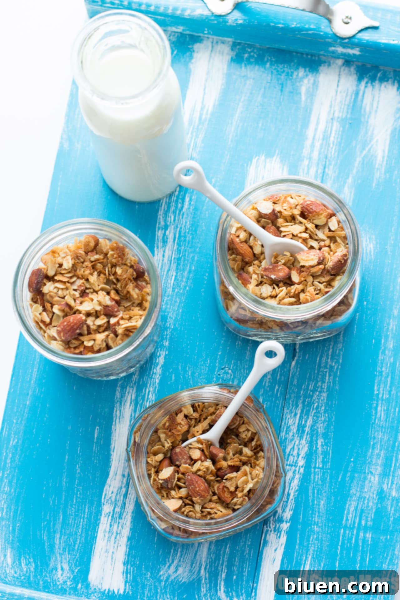 Rich Vanilla Almond Granola 4 Freshly baked Very Vanilla Almond Granola cooling on a parchment-lined baking sheet, forming clusters