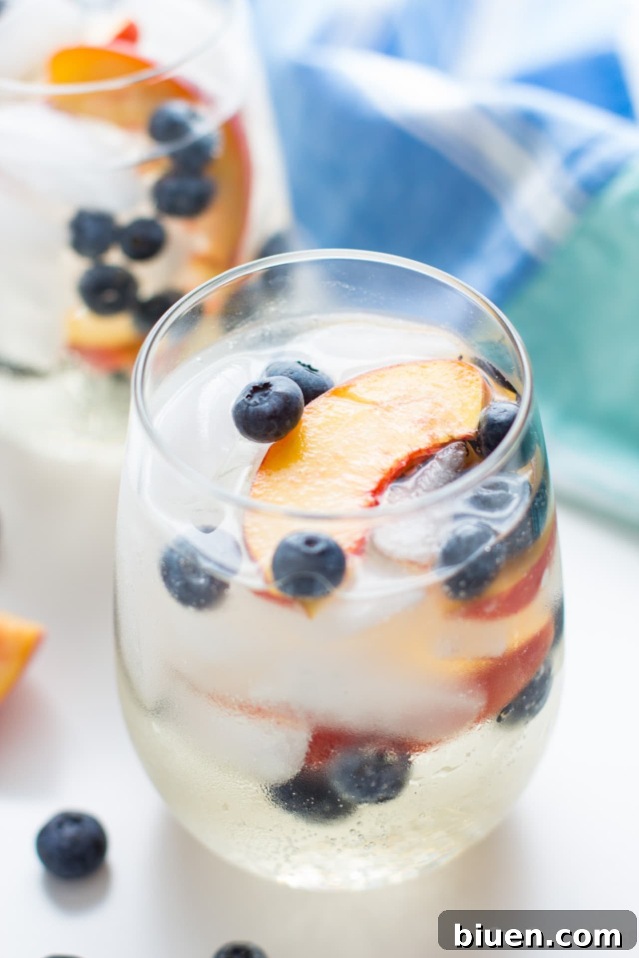 Close-up of a glass of Blueberry Peach Sangria with fruit