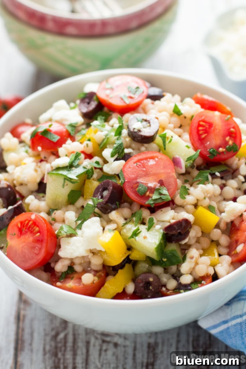 Ingredients for Greek Israeli Couscous Salad prepped on a cutting board