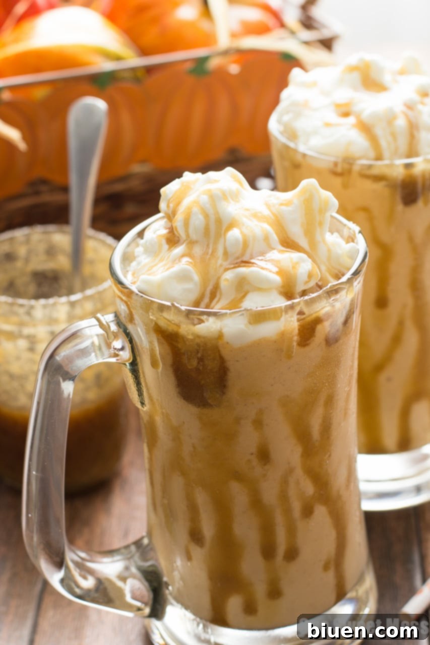 Caramel Pumpkin Pie Milkshake in a glass with a spoon, showing the thick, creamy texture