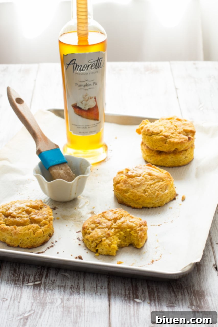 Assorted ingredients for pumpkin biscuits including pumpkin puree, butter, and spices