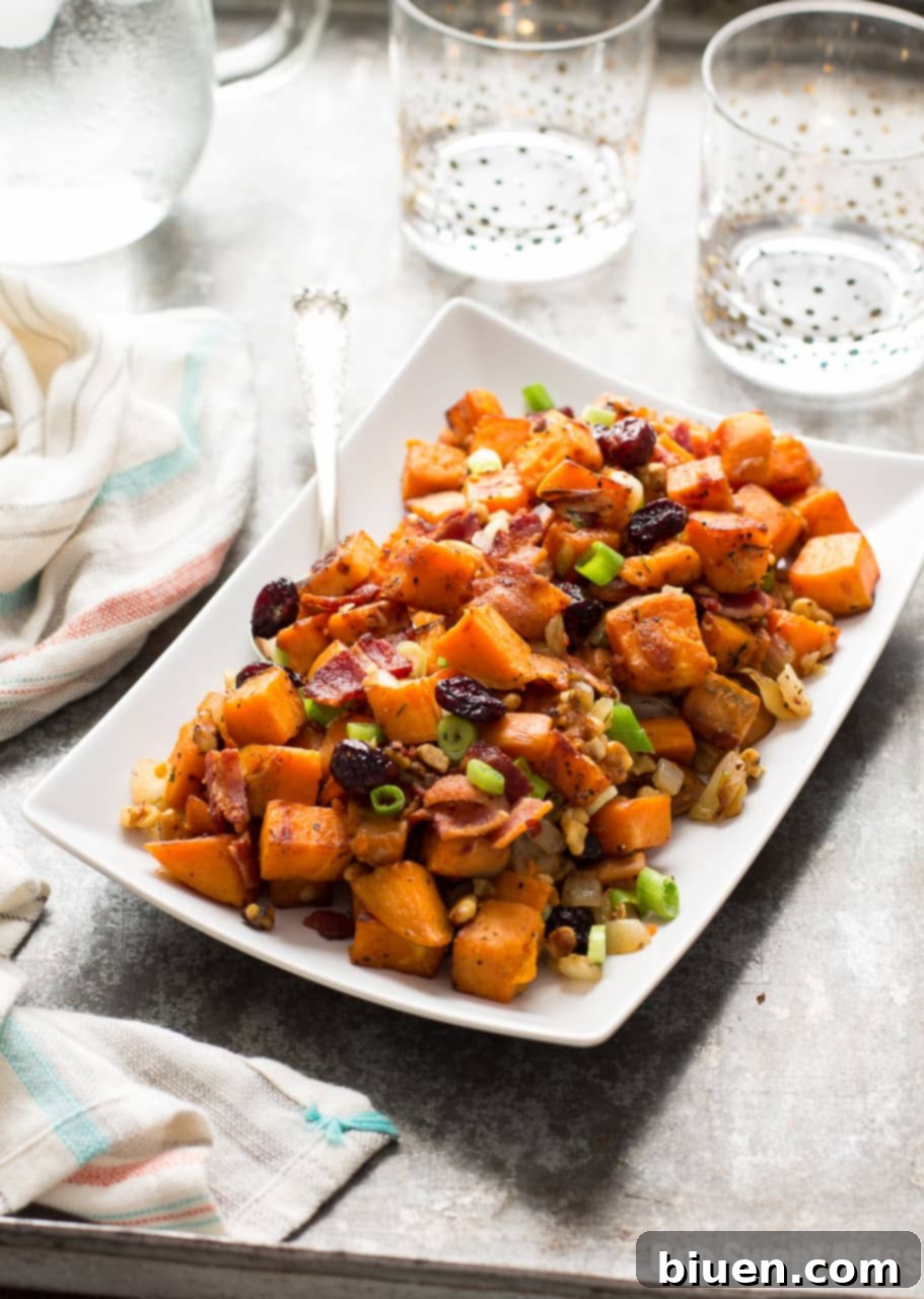 Cranberry-Walnut Sweet Potato Hash being stirred in a large sauté pan