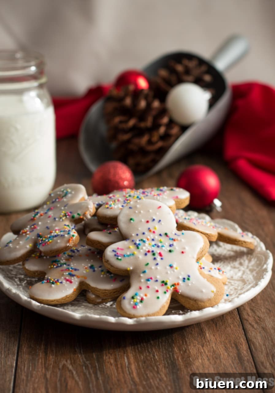 Glazed Gingerbread Men arranged on a cooling rack, freshly dipped in glaze and topped with sprinkles.