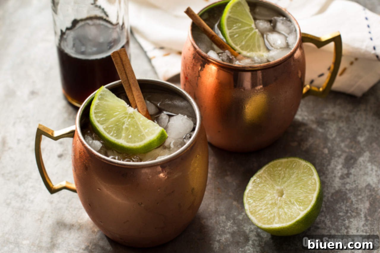 The Mid-Winter Mule: This bourbon-infused cocktail combines fruity Pimm's No.1, ginger beer, and homemade cinnamon simple syrup, presented in a copper mug with lime and cinnamon garnish.